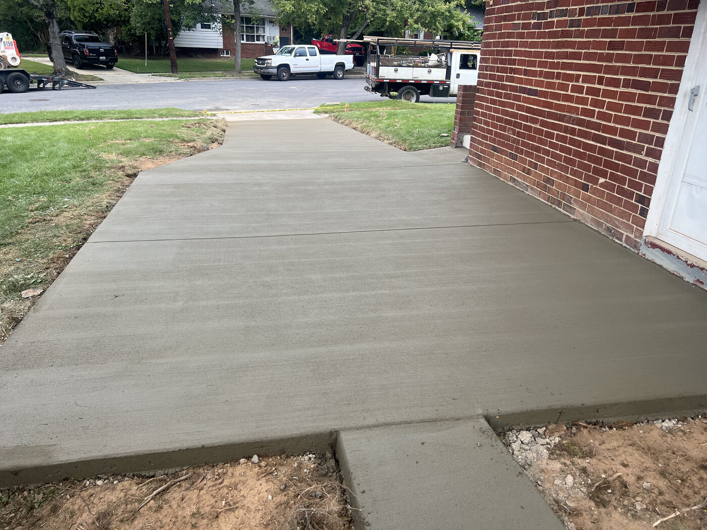 New concrete driveway pour beside a brick home