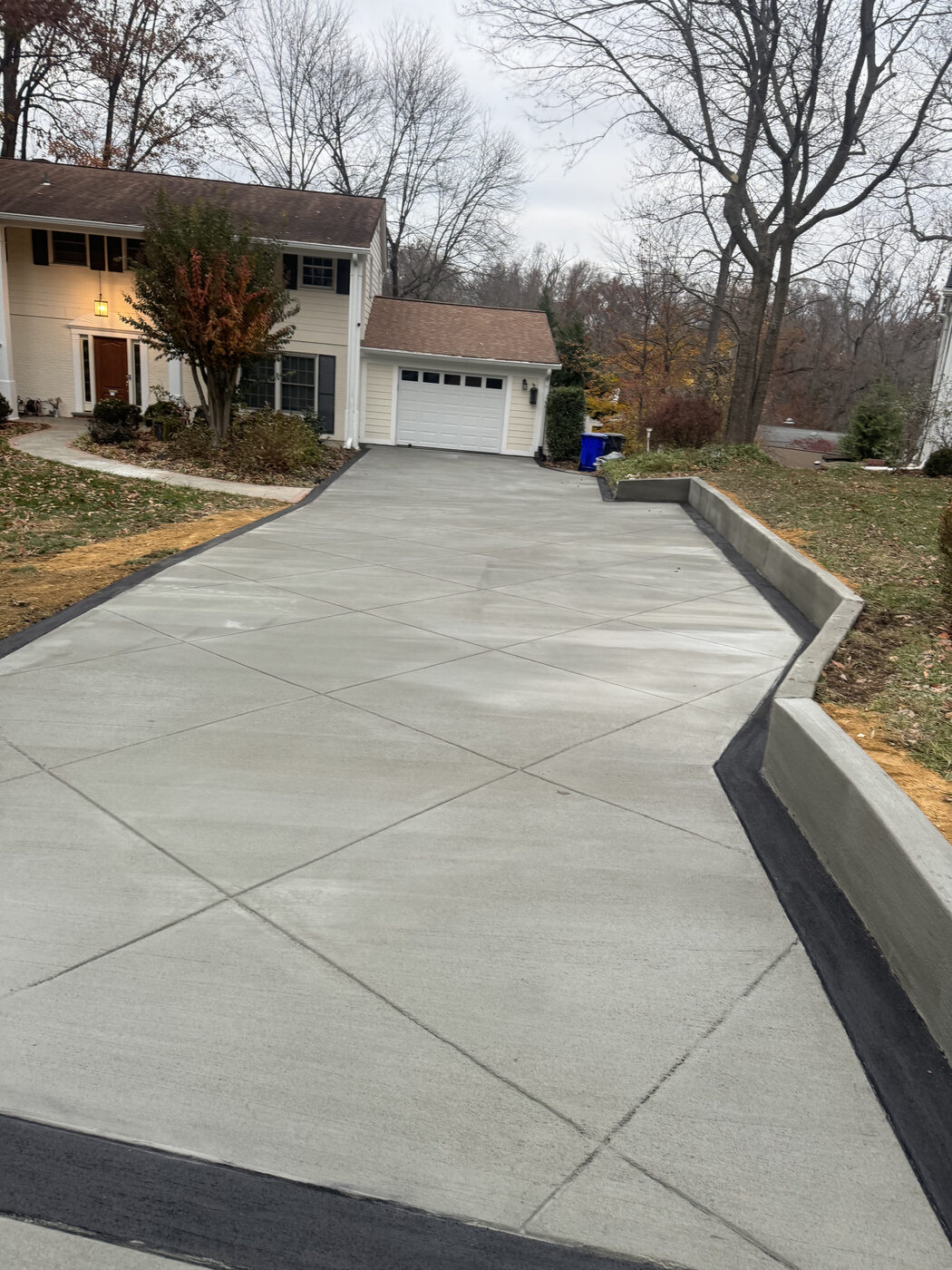 Long curved concrete driveway with a retaining wall