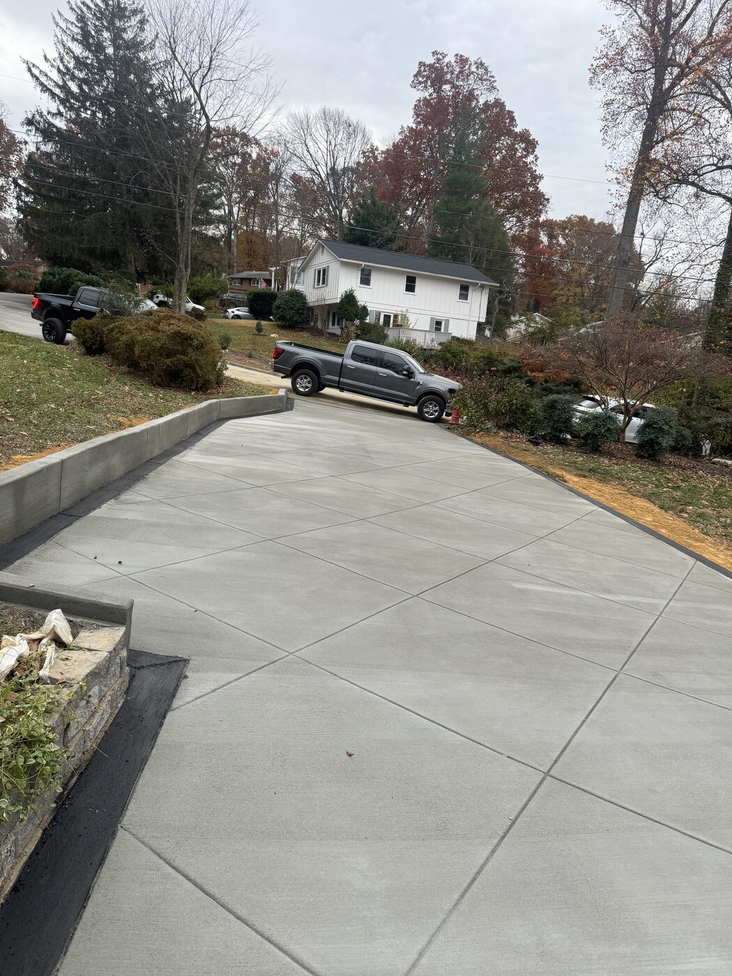 Sloped concrete driveway with a retaining wall border
