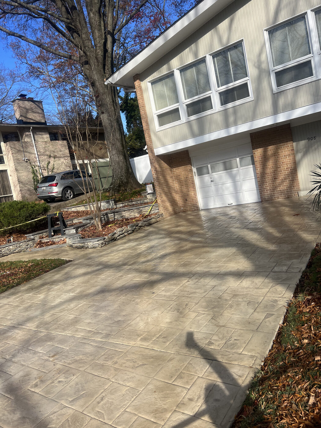 Tan stamped-pattern concrete driveway at a modern home