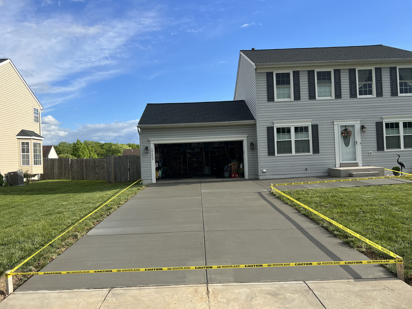 Wide concrete driveway leading to a two-car garage