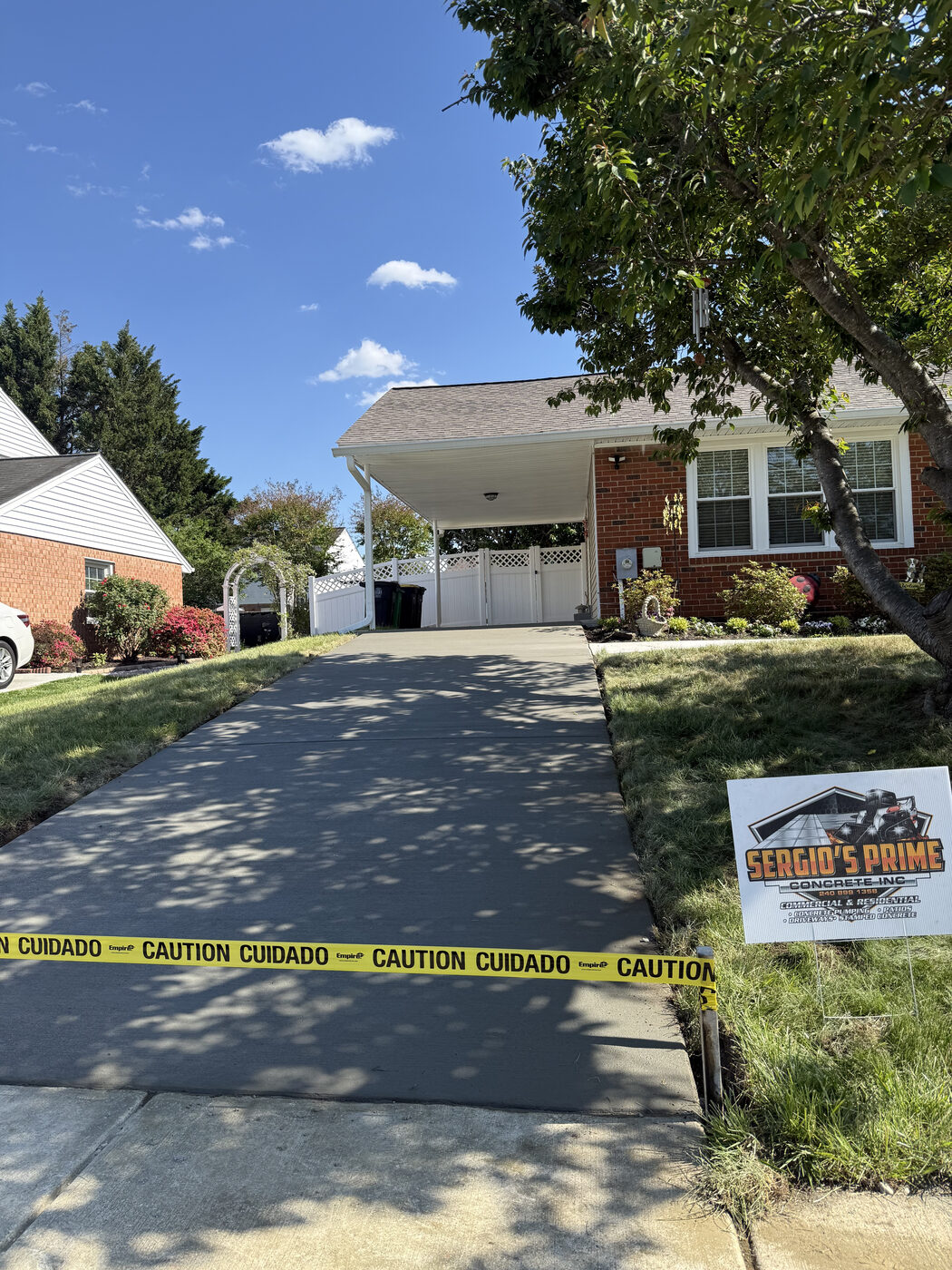 Freshly poured concrete driveway curing behind caution tape