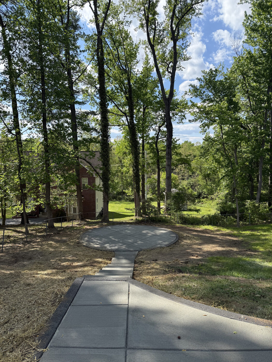 Round concrete patio pad connected by a walkway