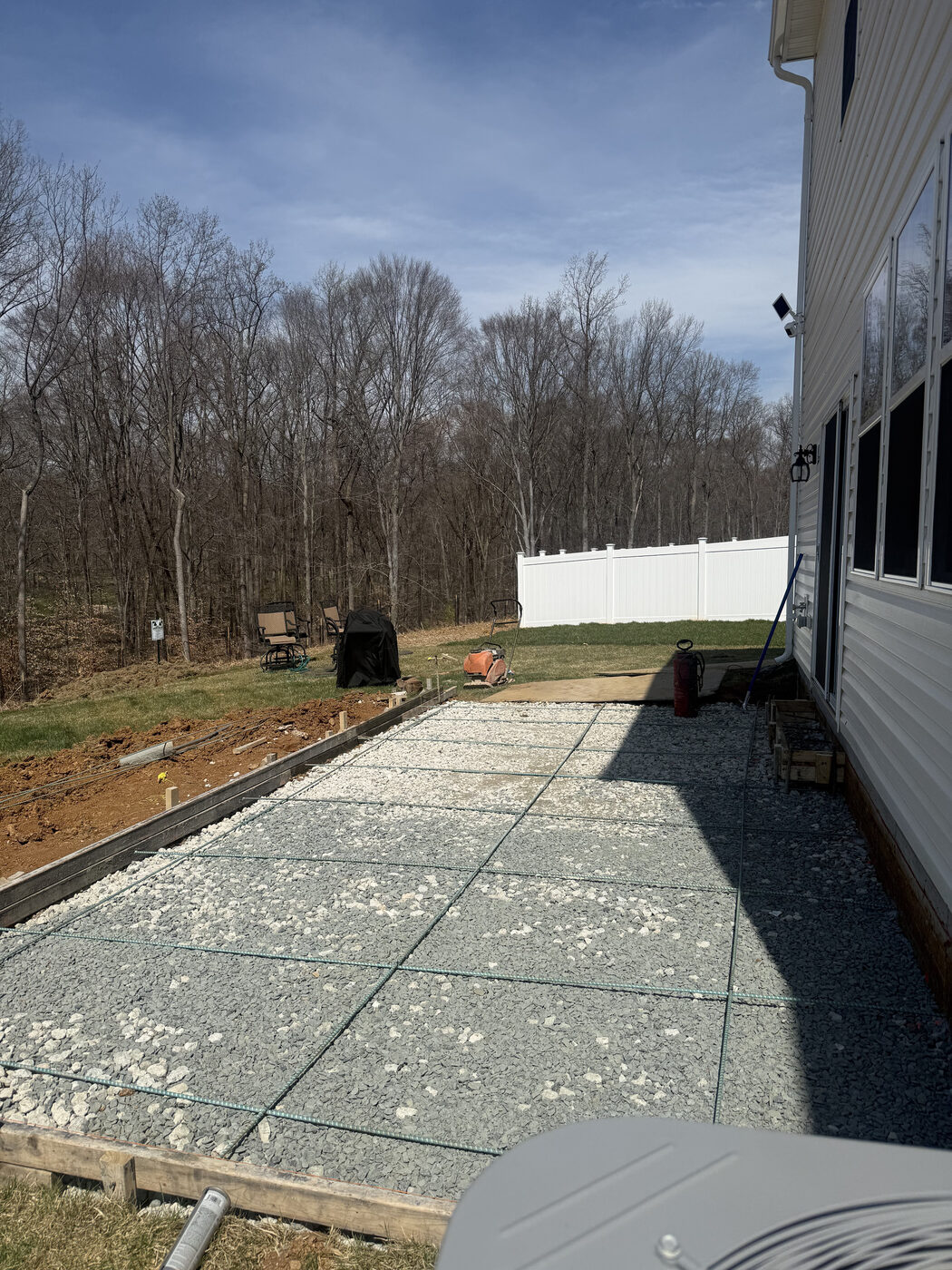 Gravel base laid before a patio pour beside a home