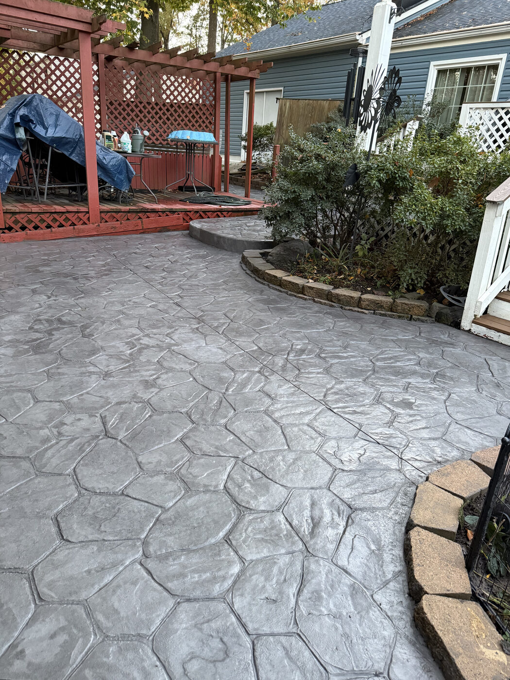 Curved stamped stone-pattern patio with a decorative border