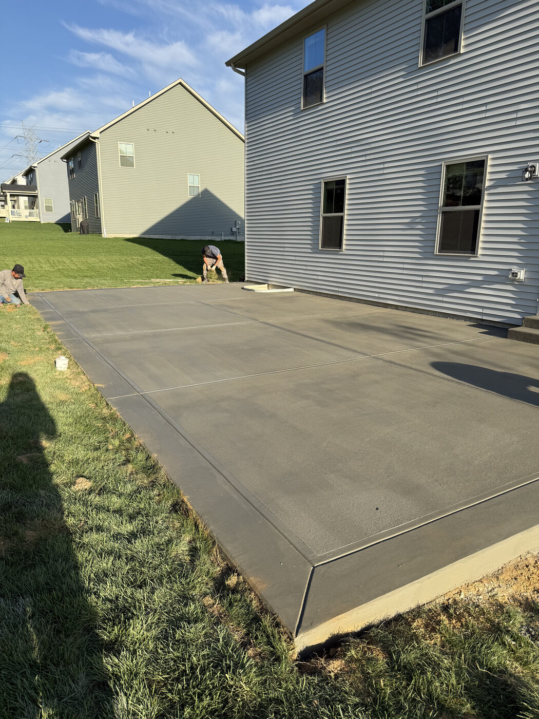 Crew hand-finishing a freshly poured concrete patio
